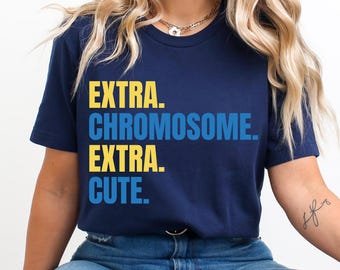 May include: A navy blue t-shirt with the text "EXTRA. CHROMOSOME. EXTRA. CUTE." in yellow and blue lettering.