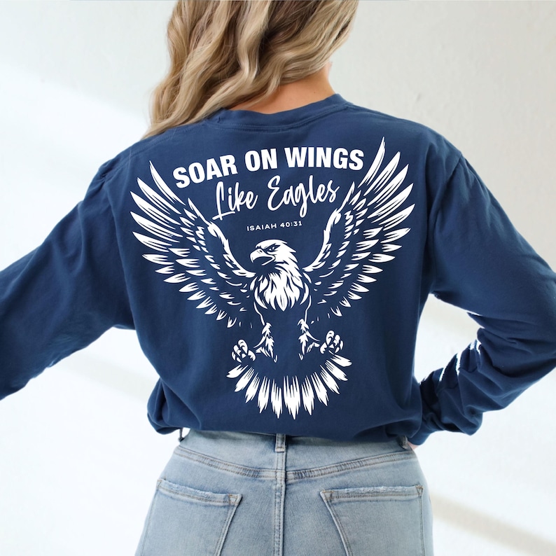 May include: A navy blue long-sleeve shirt with a white eagle graphic and the text "Soar on Wings Like Eagles Isaiah 40:31".