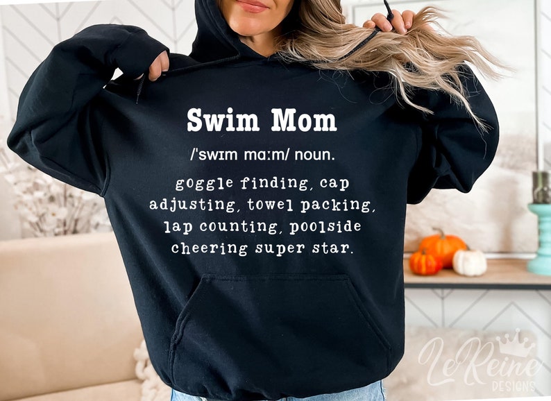 Puede incluir: Sudadera con capucha negra con texto blanco que dice "Swim Mom /'swım ma:m/ noun. goggle finding, cap adjusting, towel packing, lap counting, poolside cheering super star."