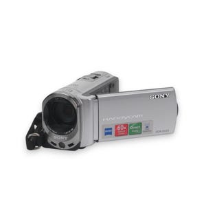 Puede incluir: Una videocámara Sony Handycam DCR-SX33 plateada con lente Carl Zeiss Vario-Tessar, zoom óptico de 60x y función Direct Copy. El dispositivo incluye una correa de muñeca negra y muestra el logotipo de Sony en el lateral y el frontal.