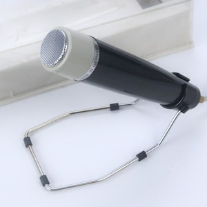 May include: A black microphone with a silver grille and a stand. The microphone has the text "Made in Germany" printed on the side.
