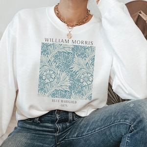 May include: White sweatshirt with a blue floral print and the text "William Morris" and "Blue Marigold - 1875" printed on the front.