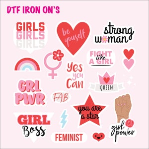 May include: A collection of colorful DTF iron-on transfers with empowering phrases and graphics. Designs include "GIRLS," "be yourself," "strong woman," a rainbow, a crown, a fist, and the words "GRL PWR," "GIRL BOSS," and "FEMINIST."