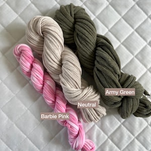 Peut inclure: Trois écheveaux de fil de différentes couleurs : vert armée, neutre et rose Barbie. Le fil est fait d’un matériau doux et texturé.