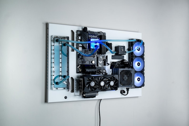 May include: A white wall-mounted computer system with a custom water-cooling loop. The system features a motherboard, graphics card, and multiple fans with blue LED lighting.
