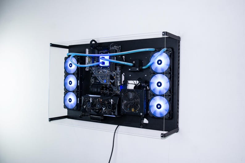 May include: A black computer case with a clear acrylic front panel. The case is mounted on a wall and has multiple blue LED fans visible. The case is open and shows the internal components of the computer, including the motherboard, graphics card, and power supply.