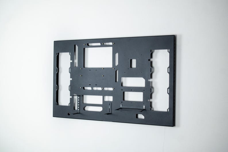 May include: A black metal frame with cutouts for various components. The frame is designed for a computer case and has slots for motherboard, hard drives, and other components.