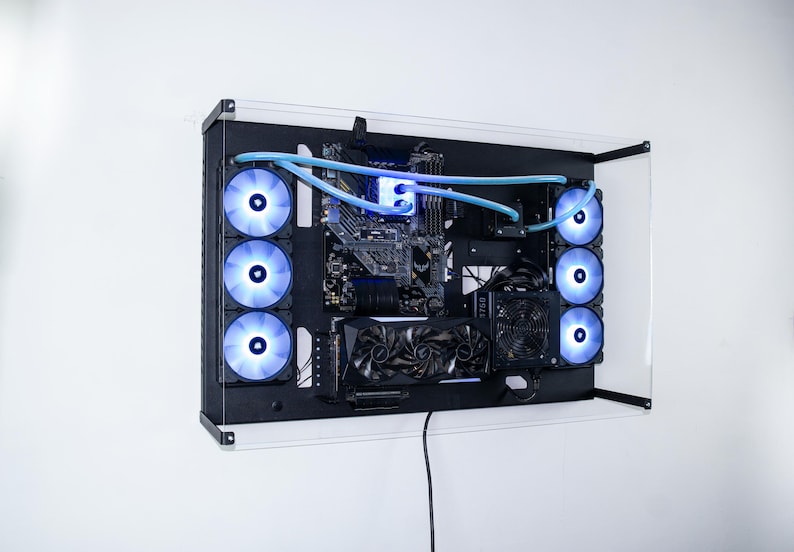 May include: A black computer case with a clear acrylic front panel. The case is mounted on a wall and has multiple blue LED fans visible. The case is open and shows the internal components of the computer, including the motherboard, graphics card, and cooling system.