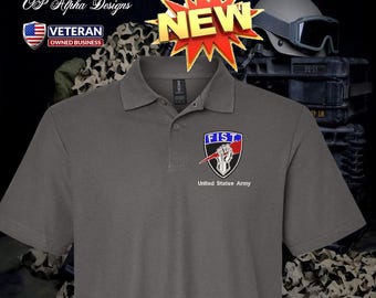 Può includere: Polo grigio con un emblema "FIST" e il testo "United States Army". L'emblema presenta un pugno chiuso in rosso, bianco e blu. La maglietta ha anche una grafica "NEW" e un logo "Veteran Owned Business".