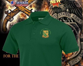 Può includere: Polo verde con una toppa di battaglione di polizia militare con un trifoglio verde e il testo "39th Military Police Battalion" e "Justice to All".