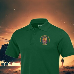 May include: A green polo shirt with an embroidered patch that reads "Special Operations Command Central" with a crest featuring a winged eagle and a sword.
