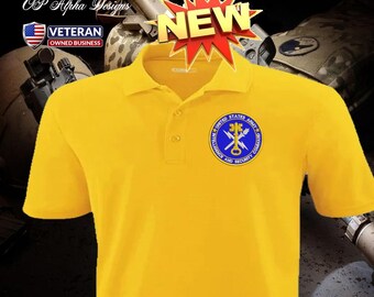Può includere: Una polo giallo brillante con colletto button-down e maniche corte. La maglietta presenta una toppa circolare con la scritta "INTELLIGENCE UNITED STATES ARMY COMMAND" e un disegno a stella. Una grafica "NEW" è sopra la maglietta.