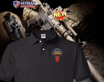 Può includere: Una polo nera con una toppa ricamata sul petto sinistro. La toppa raffigura un paracadute con il testo Special Forces, Ranger e Airborne, e un pugnale rosso. La maglia presenta un colletto e un'abbottonatura a tre bottoni.