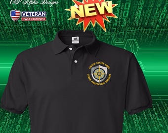 Può includere: Una polo nera con un emblema ricamato della United States Army Cyber Protection Brigade sul petto sinistro. L'emblema include uno scudo, una stella bussola e del testo. Un grafico a stella rossa con la parola NEW si trova in alto.