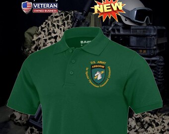 Può includere: Una polo verde scuro con una paramontura a tre bottoni e maniche corte. La maglietta presenta una toppa ricamata con la scritta "U.S. ARMY AIRBORNE" e un'emblema di unicorno. La maglietta ha anche la scritta "1st Special Operations Command (Airborne)". L'immagine include la scritta "NEW".