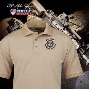Pu&ograve; includere: Una polo beige con un logo ricamato nero delle Forze Speciali dell'esercito americano sul petto sinistro. La polo &egrave; a maniche corte e con colletto.