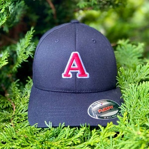 May include: A black baseball cap with a red embroidered letter "A" on the front. The cap has a Flexfit label on the back.