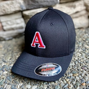 May include: Black baseball cap with a red felt letter 'A' on the front. The cap has a black Flexfit Youth label on the back.