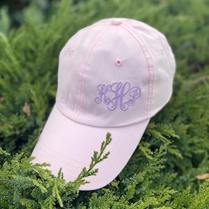 May include: A pink baseball cap with a purple embroidered monogram "HLL" on the front.