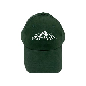May include: A dark green baseball cap with a white embroidered design of mountains, a moon, and birds.