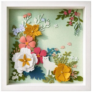 Peut inclure: Un cadre carré blanc contenant une œuvre d'art en papier superposé sur un fond vert clair. Elle présente la silhouette d'un chat blanc entourée de fleurs en papier multicolores dans des tons de blanc, jaune, rose et bleu, avec du feuillage vert.