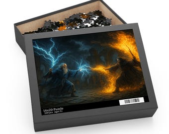 Op de afbeelding: Puzzeldoos met een fantasiekunstscène van twee tovenaars die spreuken uitspreken. De ene tovenaar hanteert blauwe bliksem, de andere oranje vuur. De doos is open en onthult puzzelstukjes. Tekst: "16x20 Puzzle 500 pcs Ages 9+". Afmetingen: 40,6 x 50,8 cm.