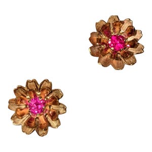 May include: A pair of gold tone flower-shaped earrings with pink gemstones in the center.