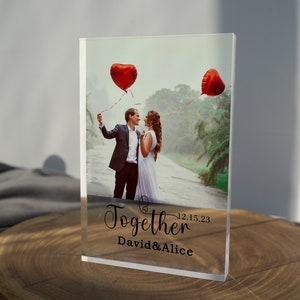 Könnte beinhalten: Ein transparenter Acrylblock mit einem Foto eines Paares, das rote Herzballons hält. Der Text "Together 12.15.23 David & Alice" ist auf den Block gedruckt.