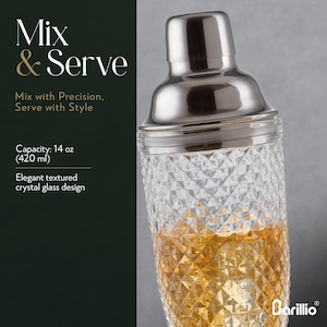 Puede incluir: Una coctelera de acero inoxidable con una base de cristal texturizado, llena de un l&iacute;quido dorado y hielo. La imagen incluye el texto "Mix & Serve". La coctelera tiene una capacidad de 420 ml. El dise&ntilde;o es elegante.