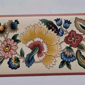 Puede incluir: Borde de papel pintado floral con un patrón repetitivo de flores estilizadas en tonos azules, amarillos, rojos y verdes. Las flores se colocan sobre un fondo crema con un borde rojo fino.