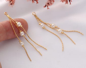 May include: Two gold chain earrings with three white pearl beads on each chain.