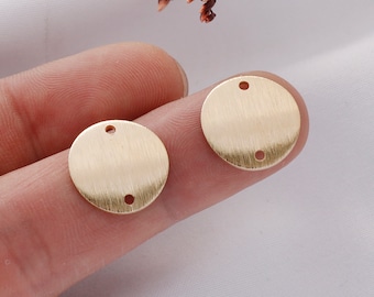 May include: Two gold-colored metal circles with two holes each. The circles are smooth and have a brushed finish.