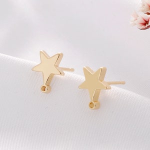 May include: A pair of gold star-shaped earring charms with a small loop at the bottom of each star.
