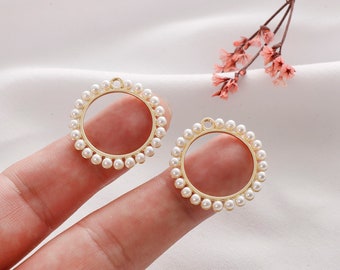 May include: Two gold-toned circular earring blanks with a ring of white faux pearls around the edge.