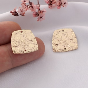 May include: Two gold-toned metal square-shaped charms with a textured surface and two holes each.