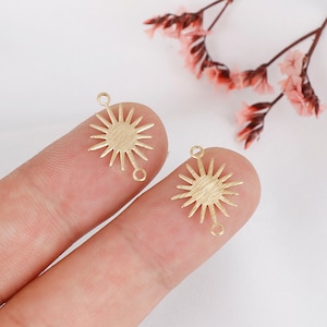 May include: Two gold-toned metal sunburst charms with a textured finish. Each charm has two jump rings for attaching to jewelry.