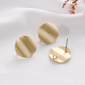 May include: A pair of gold-toned round earrings with a smooth, slightly curved surface. The earrings have a post back closure.