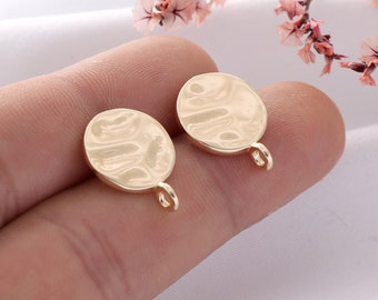 May include: Two gold-toned metal round pendant charms with a textured surface and a loop for attaching to jewelry.