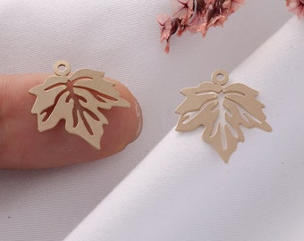 May include: Two gold-colored metal maple leaf charms with a hole at the top for attaching to jewelry or other crafts.