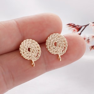 May include: Two gold-tone metal earring findings with a rope-like design. Each finding has a small loop at the bottom.