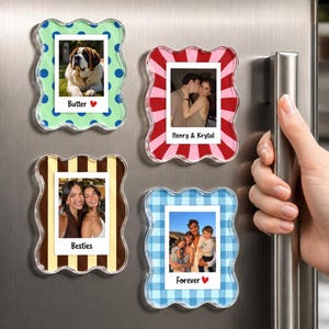 May include: Four rectangular acrylic photo frames with wavy edges, each displaying a different photograph. The frames feature patterns including blue polka dots, pink and red sunburst stripes, brown and tan stripes, and blue gingham check.