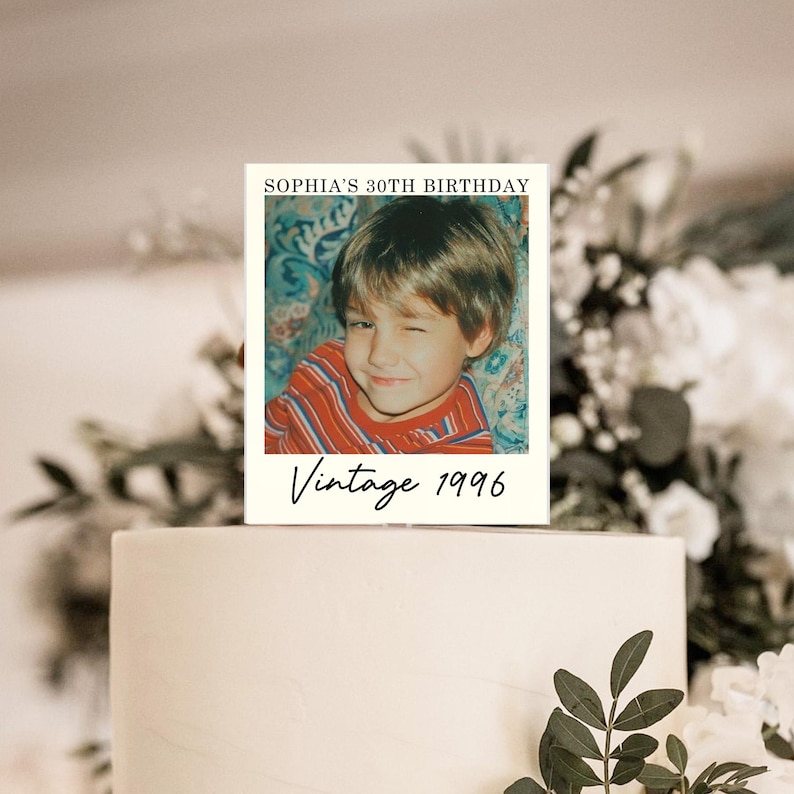 K&ouml;nnte beinhalten: Ein rechteckiger Tortenstecker mit einem Foto eines zwinkernden Kindes in einem rot-blau gestreiften T-Shirt. Der Text oben lautet SOPHIA'S 30TH BIRTHDAY in schwarzen Gro&szlig;buchstaben, und der Text unten lautet Vintage 1996.