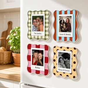 May include: Four wavy-edged magnetic photo frames featuring distinct patterns: green gingham, blue and orange stripes, red and pink blocks, and yellow with brown polka dots. Each frame holds a square photograph with a white border and custom text.