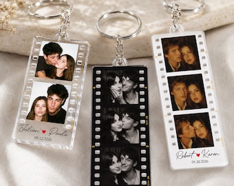 May include: Three rectangular keychains designed like film strips, each featuring two or three portrait photos of couples. The keychains include silver metal rings and chains. Printed text includes names like Julian and Paula, David and Sarah, or Robert and Karen, along with dates such as 09.12.2026 or 09.20.2026.