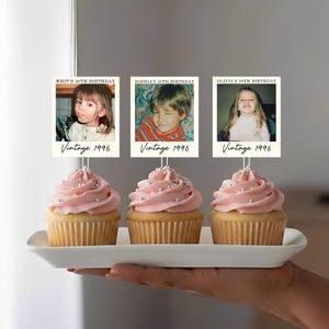 K&ouml;nnte beinhalten: Drei Cupcakes mit rosa Zuckerguss und silbernen Streuseln, jeweils gekr&ouml;nt von einer quadratischen Karte mit einem Kinderfoto. Die Karten zeigen den Text '30TH BIRTHDAY' und 'Vintage 1996' sowie die Namen Whit, Sophia und Olivia.