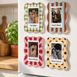 May include: Four rectangular magnetic photo frames with wavy edges, featuring green gingham, red and blue stripes, pink and red sunbursts, and yellow with brown polka dots. Each frame displays a photograph and text: The Smiths, Lucas & Amelia, Henry & Krystal, and Always & Forever.