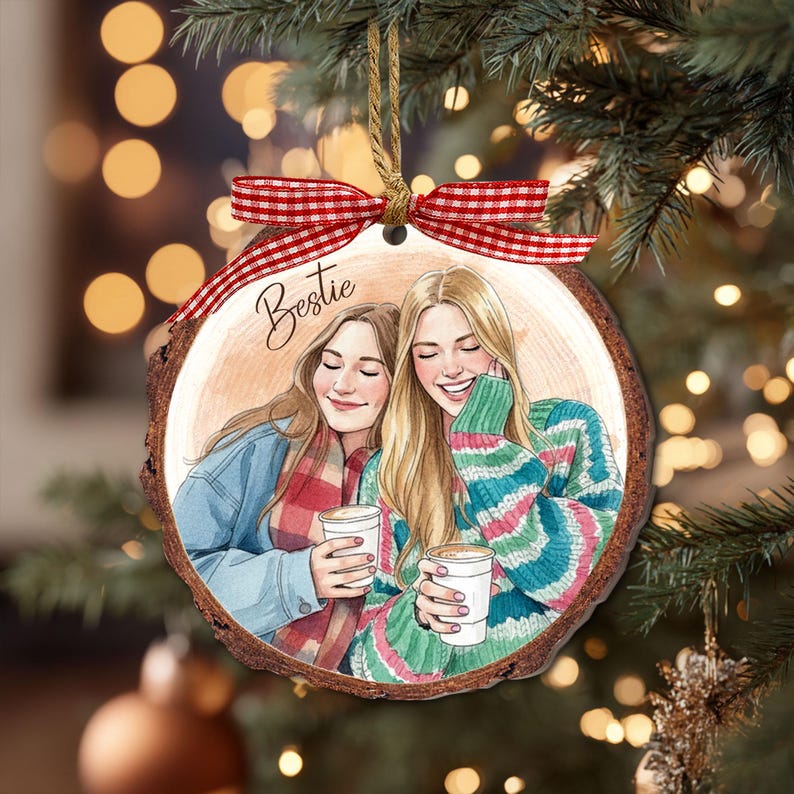 May include: A wooden Christmas ornament featuring a watercolor illustration of two smiling friends holding coffee cups. The word "Bestie" is written above the image. The ornament is decorated with a red and white checkered ribbon.