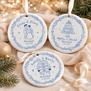 May include: Three round white ceramic ornaments with blue ink illustrations and text. Each features a floral wreath border, names, the word Married, and a date. Designs include a couple, a wedding cake, and a car with trailing cans.
