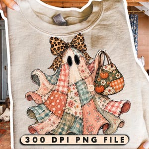 May include: A beige sweatshirt featuring a graphic of a ghost made of patchwork fabric in shades of pink, orange, and teal. The ghost wears a leopard print bow and carries a matching tote bag with pumpkins. Text at the bottom reads 300 DPI PNG FILE.