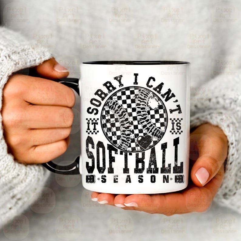 May include: White ceramic mug with a black rim and handle. The mug features a black and white graphic of a softball with the text "Sorry I can't it is softball season".